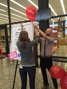 Students set up posters at DCPL to guide visitors to the basement location